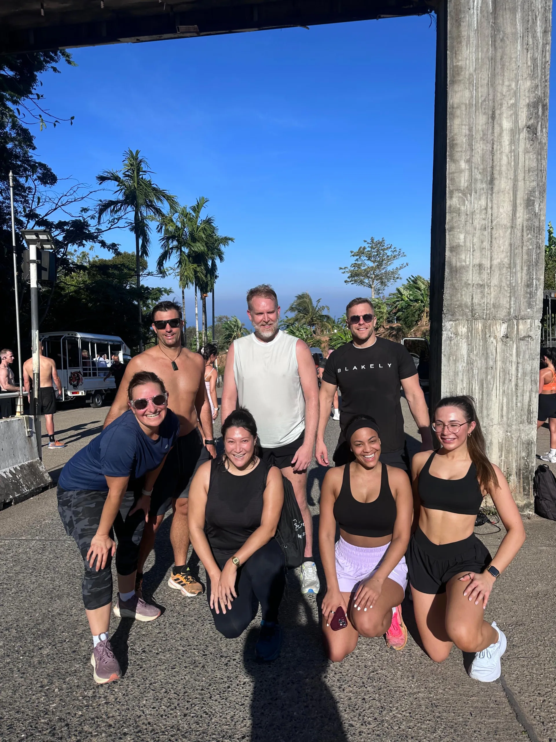 Group of fitness retreat guests kneeling and standing for a photo at the top of Big Buddha in Phuket Thailand