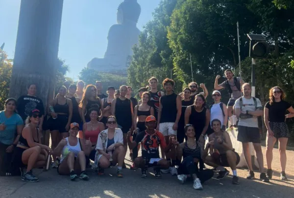 Big group of people mixed ages and genders posing at the top of the Big Buddha Statue in Phuket Thailand