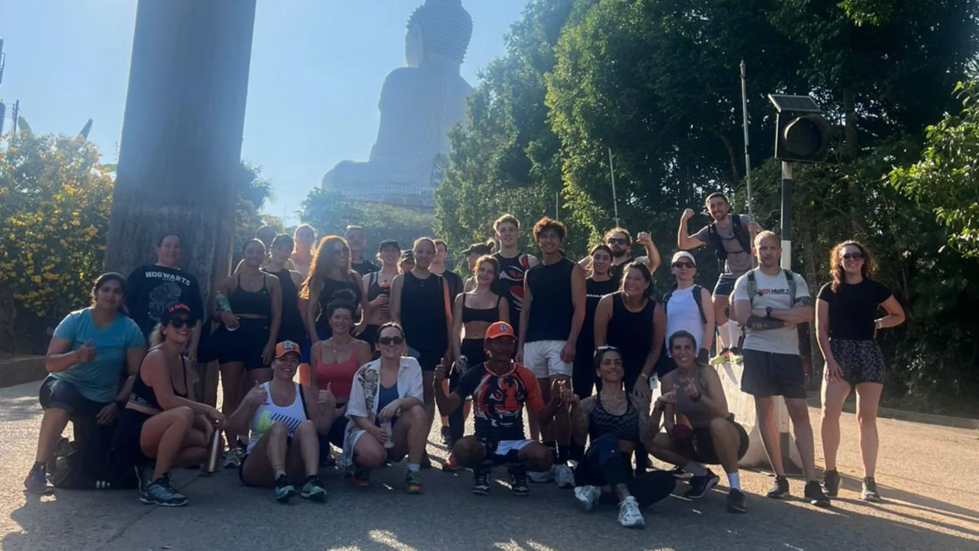 Big group of people mixed ages and genders posing at the top of the Big Buddha Statue in Phuket Thailand